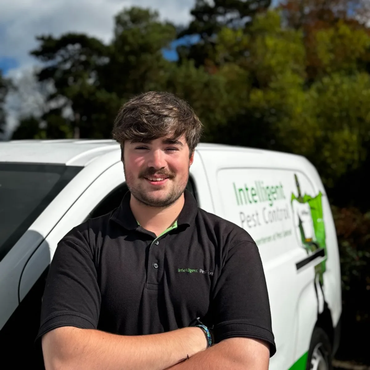 Alex Jeffrey of Intelligent Pest Control standing in front of a company van